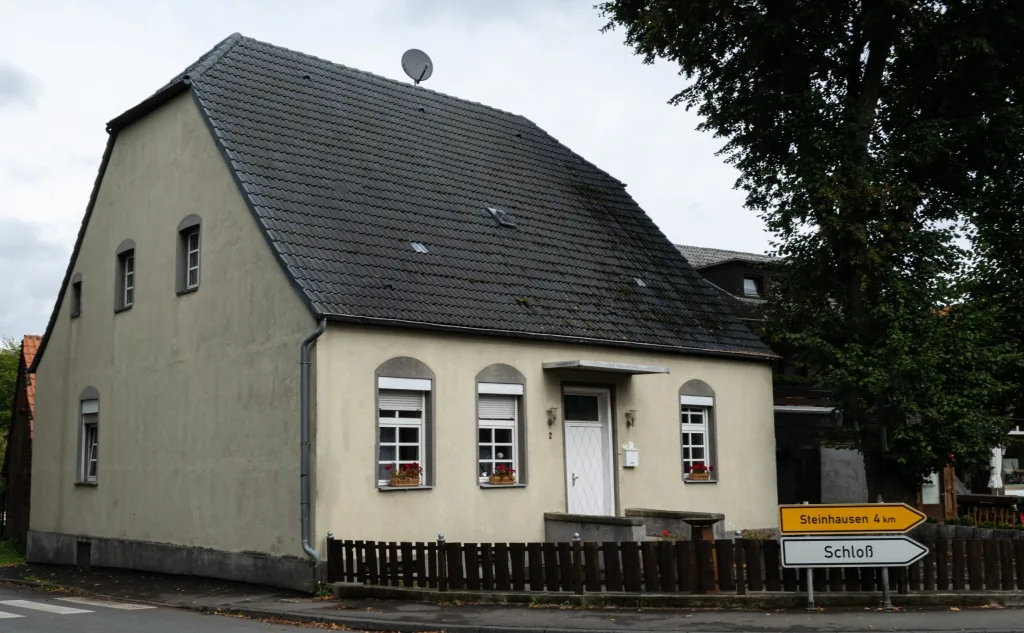 Das frühere Gasthaus heute: schlichtes Wohnhaus mit dunklem Satteldach an der Straßenecke